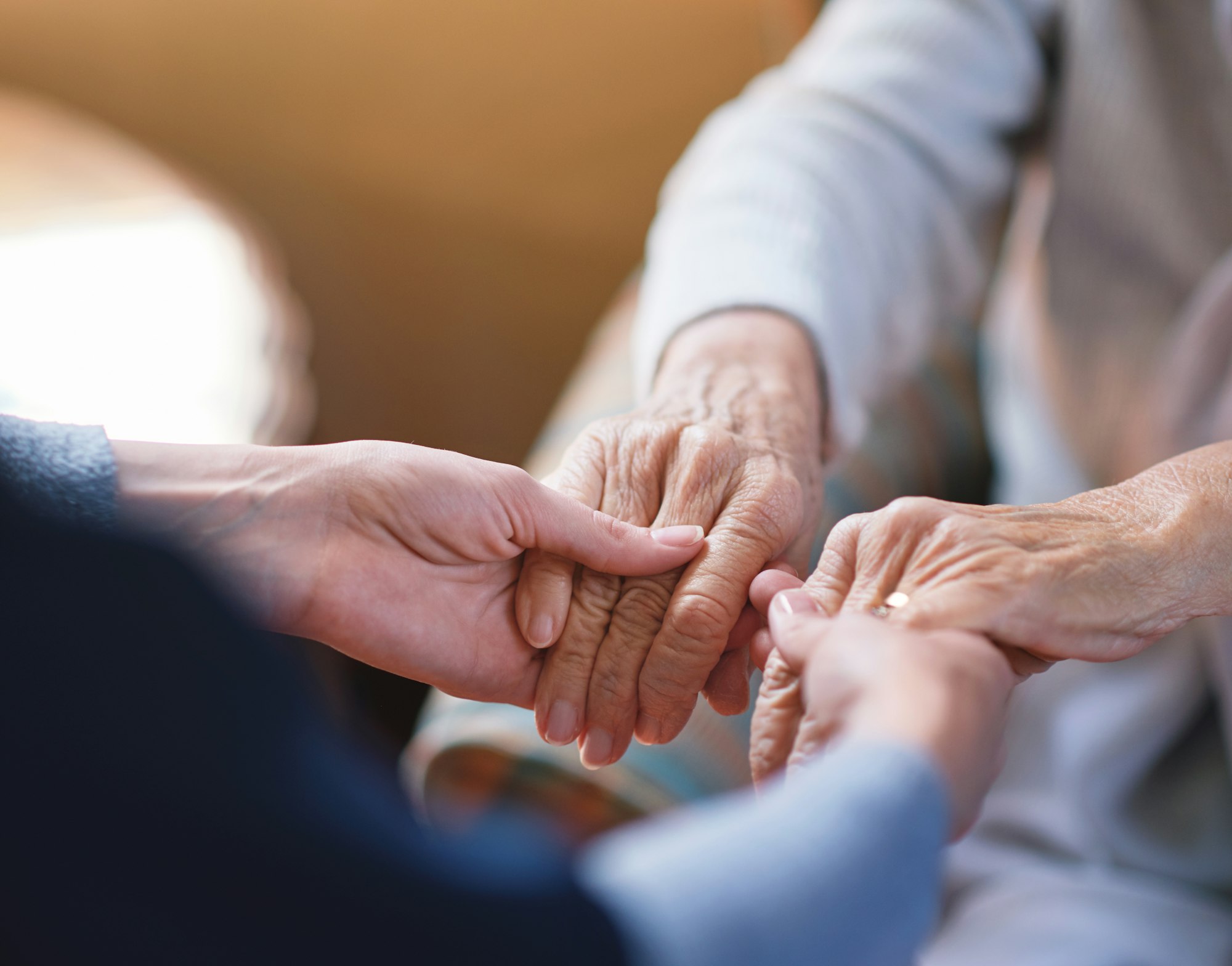 Nurse helping old woman holding hands in retirement home